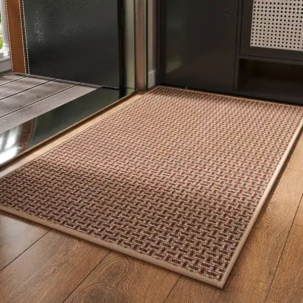 Lyxig badrumsmatta i brun färg med rutig textur, placerad på trägolv vid dörröppning.