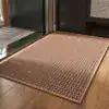 Lyxig badrumsmatta stor med mönster i brunt och beige, placerad på trägolv vid dörr.