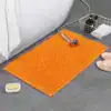 Orange badrumsmatta med mjuk fluffig textur, idealisk för badrummet.