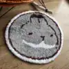 Rund badrumsmatta med kattmotiv i grått och brunt, mjuk och rundad design.