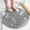 Rund duschmatta i grått med texturerad yta, används i badrummet med badkar och duschkoppling.