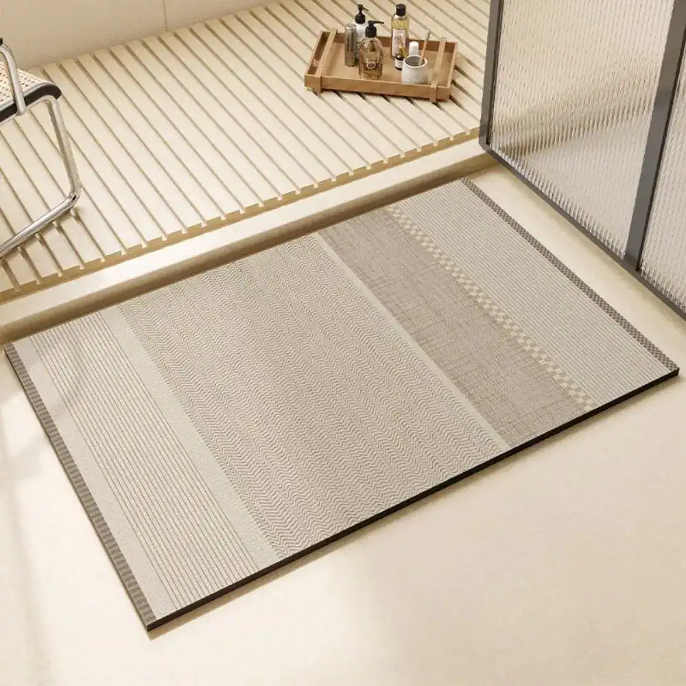 Stor badrumsmatta i diatomit, beige färg med geometriskt mönster och svart kant.