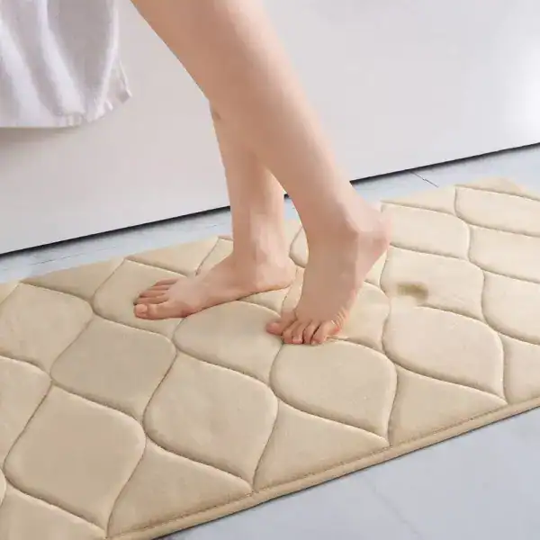 Tjock beige badrumsmatta med kvadratiskt mönster, fot på mattan i badrum.